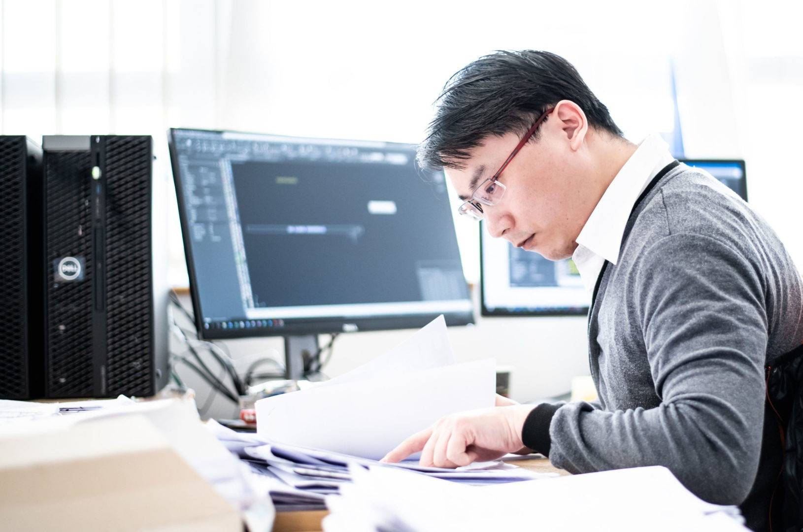 A gentleman working at a desk in front of a computer screen